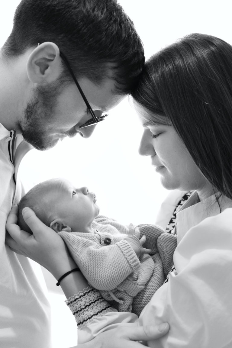 Parents avec leur bébé lors d'une séance photo en noir et blanc