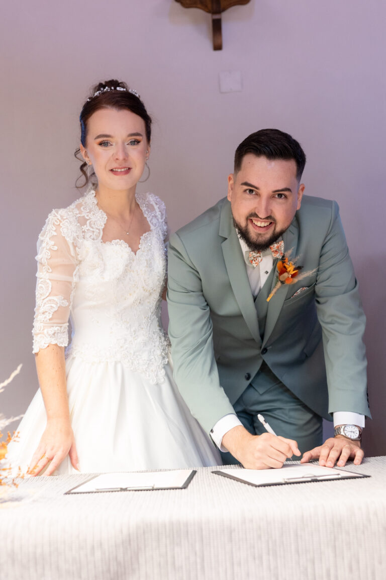 Jeanne et Pierre signent les documents de leur mariage à la mairie