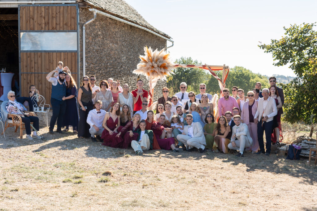 Photo de groupe des invités du mariage dans une grange familiale